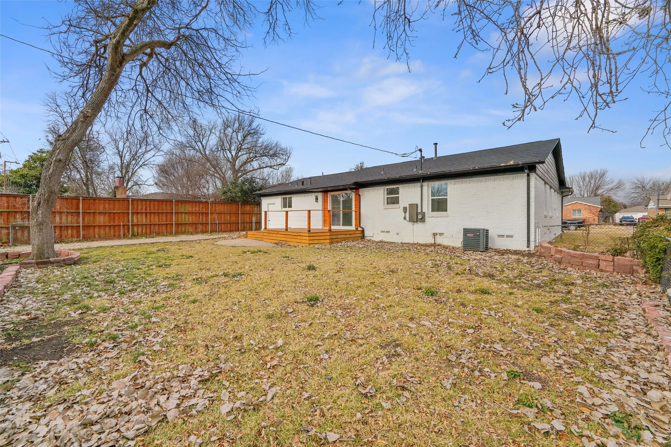 The property features a spacious backyard with a wooden fence and a deck for outdoor enjoyment