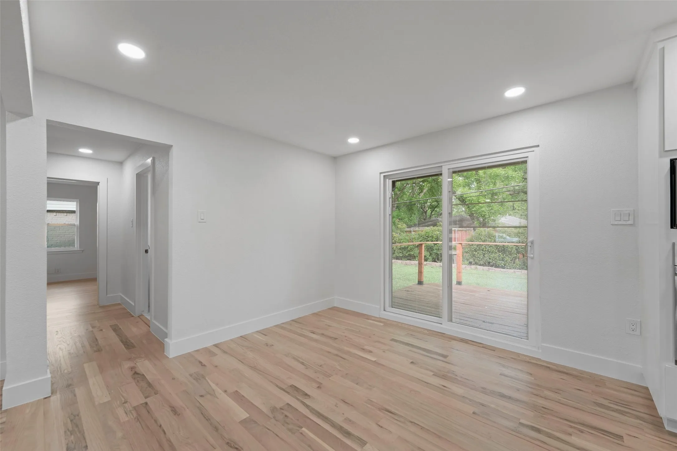 This interior space features light hardwood flooring, recessed lighting, and white walls throughout