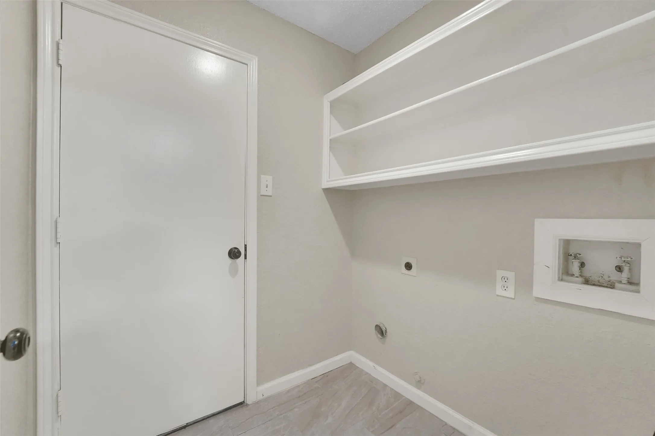 Bright, organized closet space featuring built-in shelving with integrated LED lighting, wood-finish flooring, and abundant storage capacity with clean white finishes and neutral wall tones