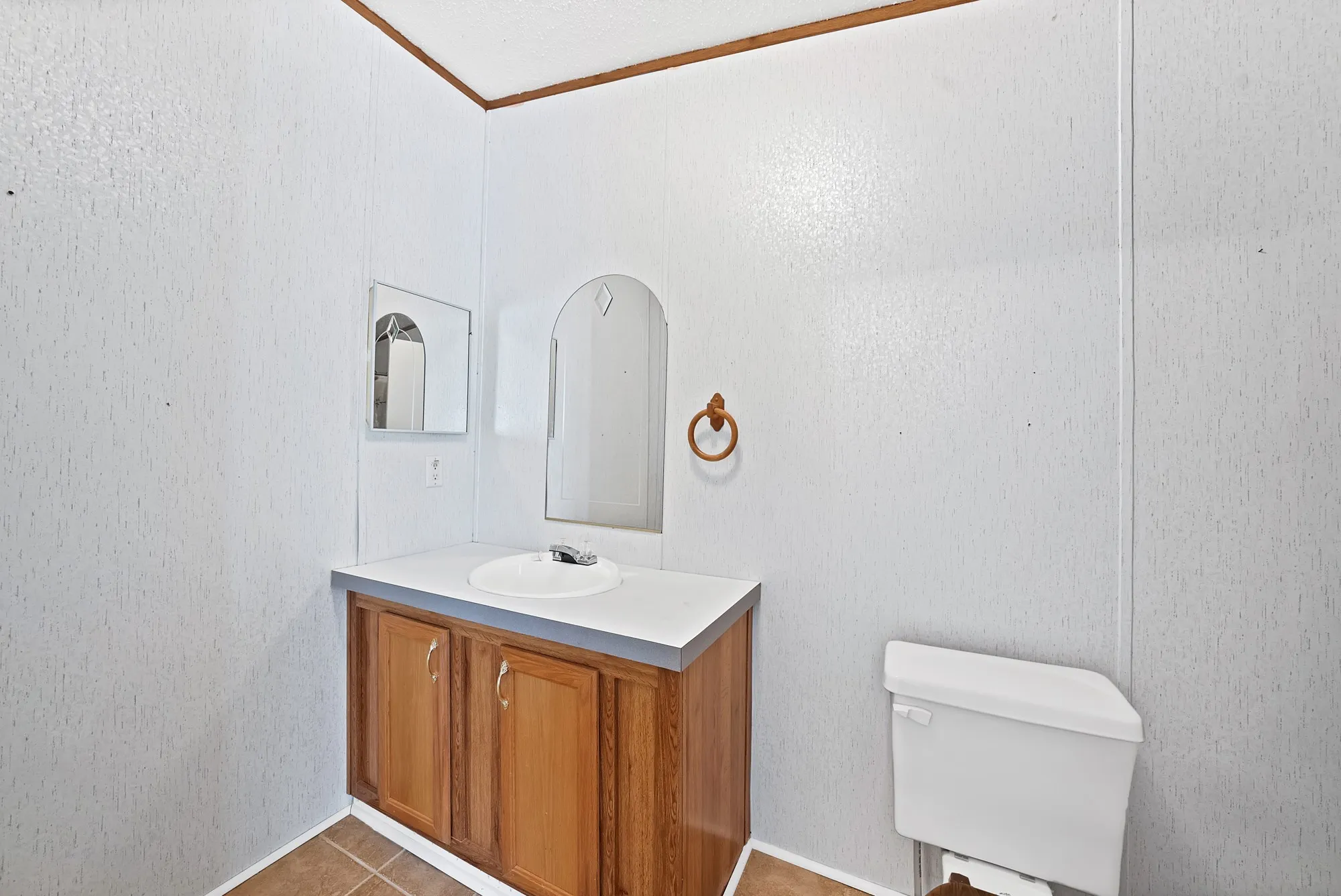 Wood-finish vanity with a white countertop and an integrated sink