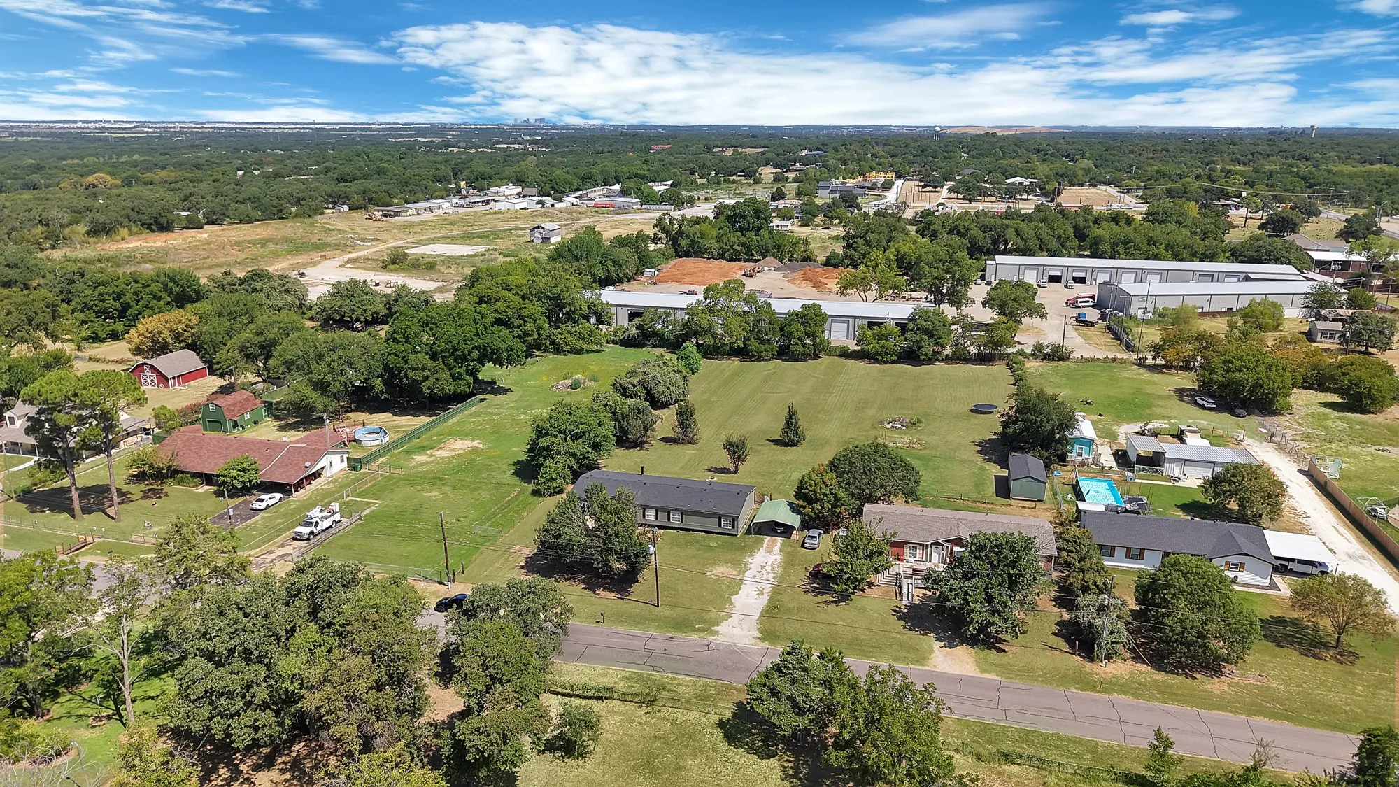 Expansive green spaces and mature trees surround residential structures