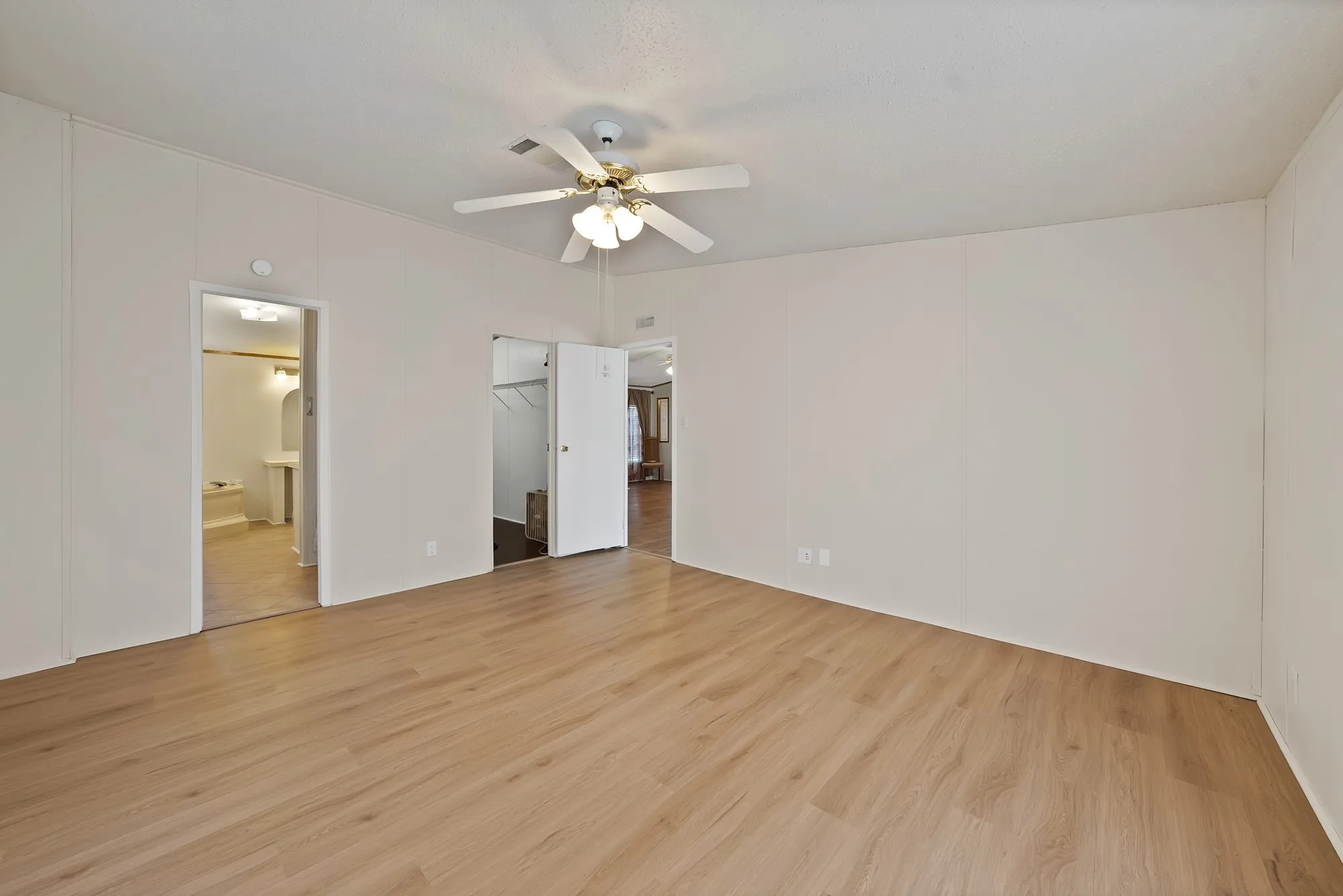 Wood-finish flooring with a ceiling fan light fixture