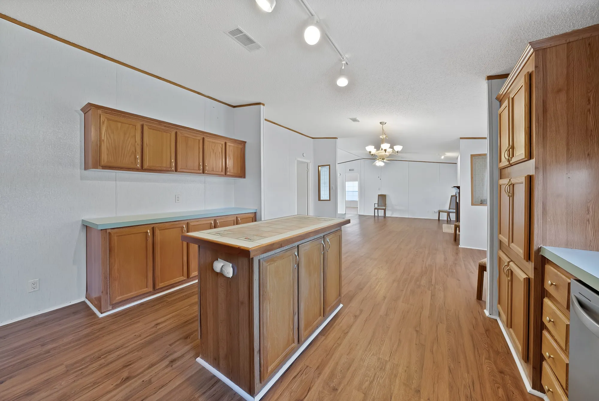 Wood-finish flooring throughout, ample wood cabinetry, a functional kitchen island, and recessed​​‌​​​​‌​​‌‌​‌‌​​​‌‌​‌​‌​‌​​​‌​​ lighting