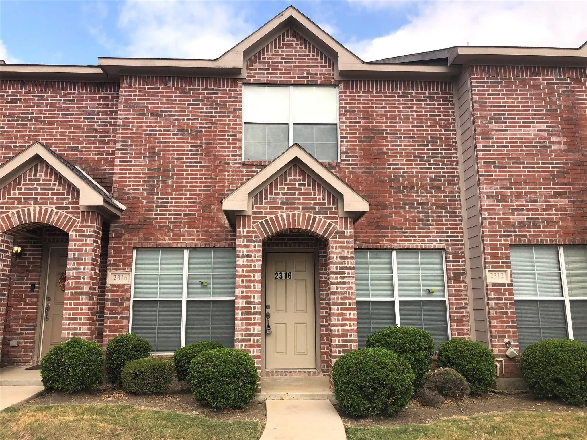 Brick exterior with arched entryway and covered porch