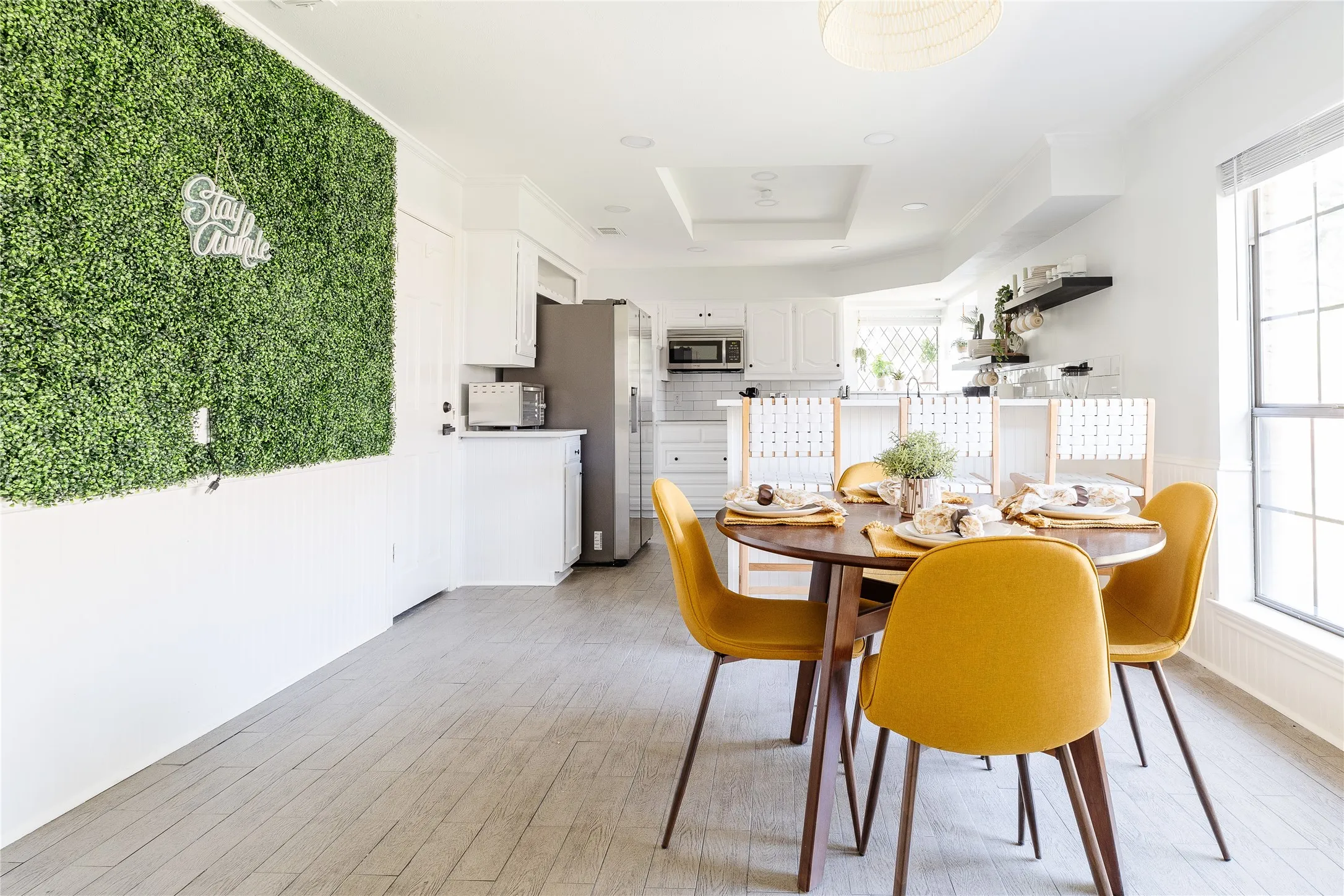 Wood-finish flooring throughout, white beadboard paneling, white shaker-style cabinetry, and recessed lighting