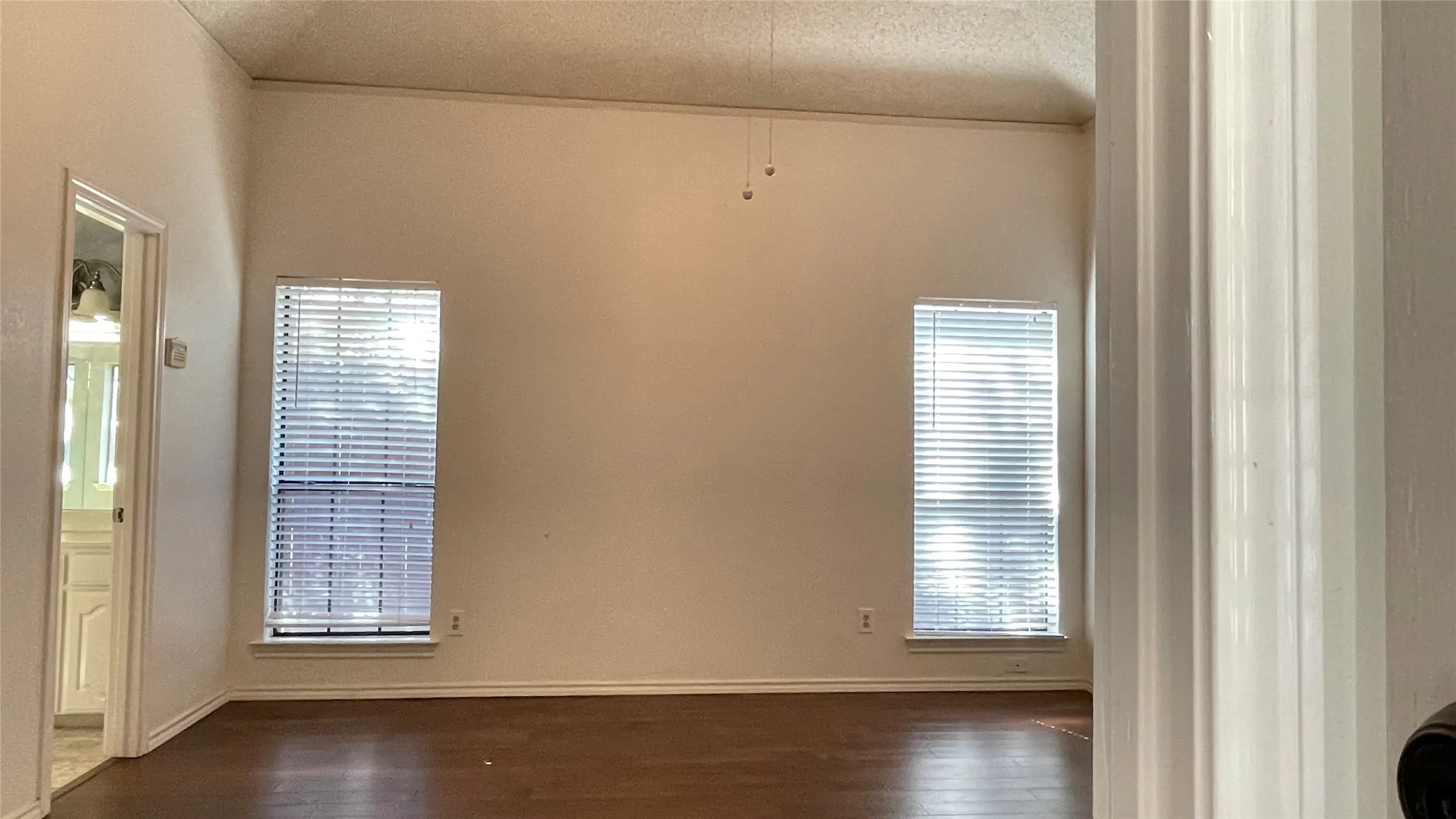 Master bedroom at rear separate from other 2 bedrooms; raised ceiling;  ceiling fan; hardwood floor