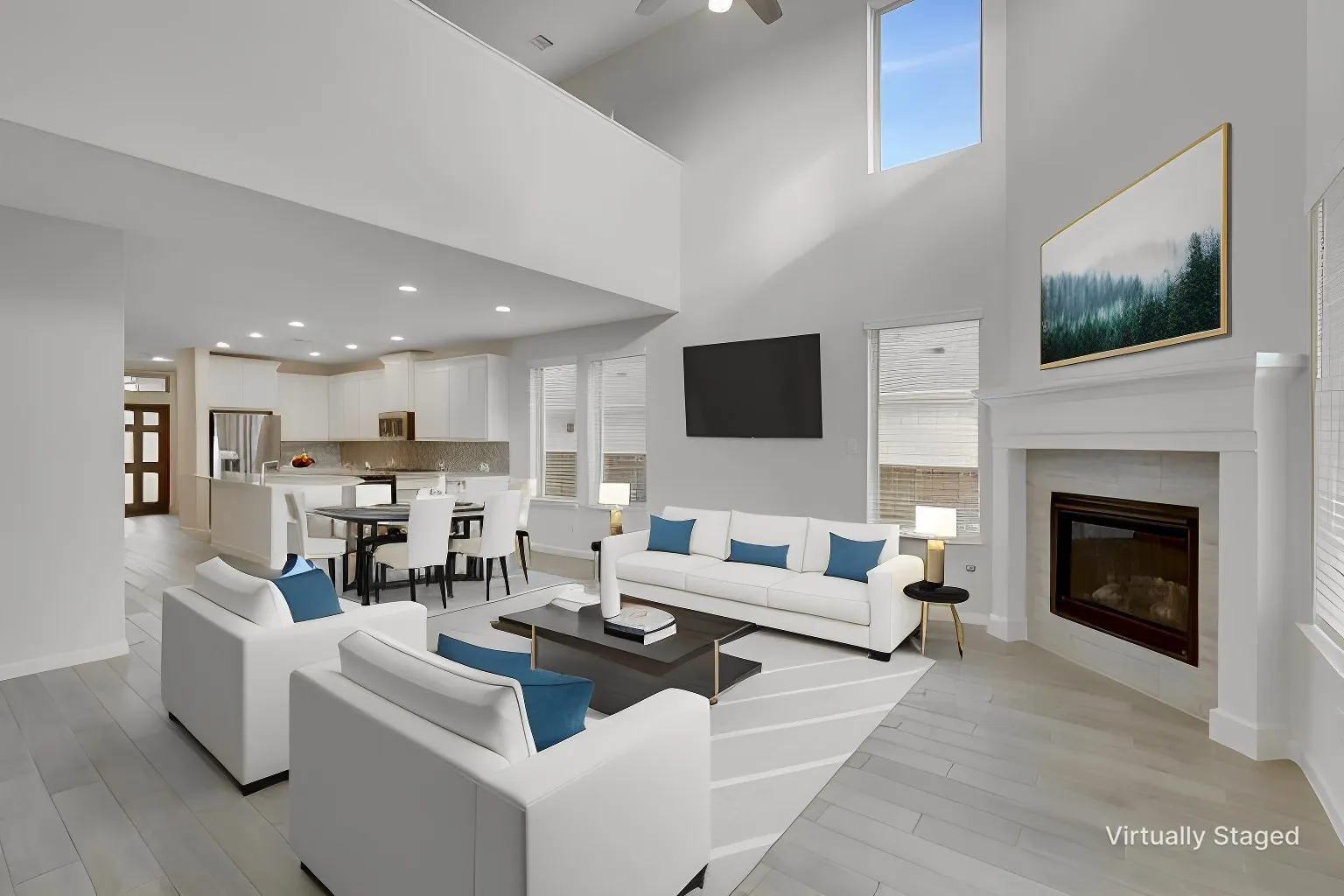 The two-story living area seamlessly connects with the kitchen and dining space for bright, open feel.