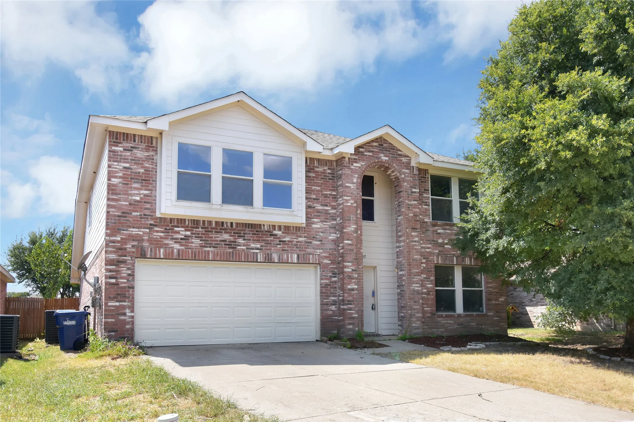 Two-story residence featuring a brick and siding exterior, an attached two-car garage, and a concrete driveway