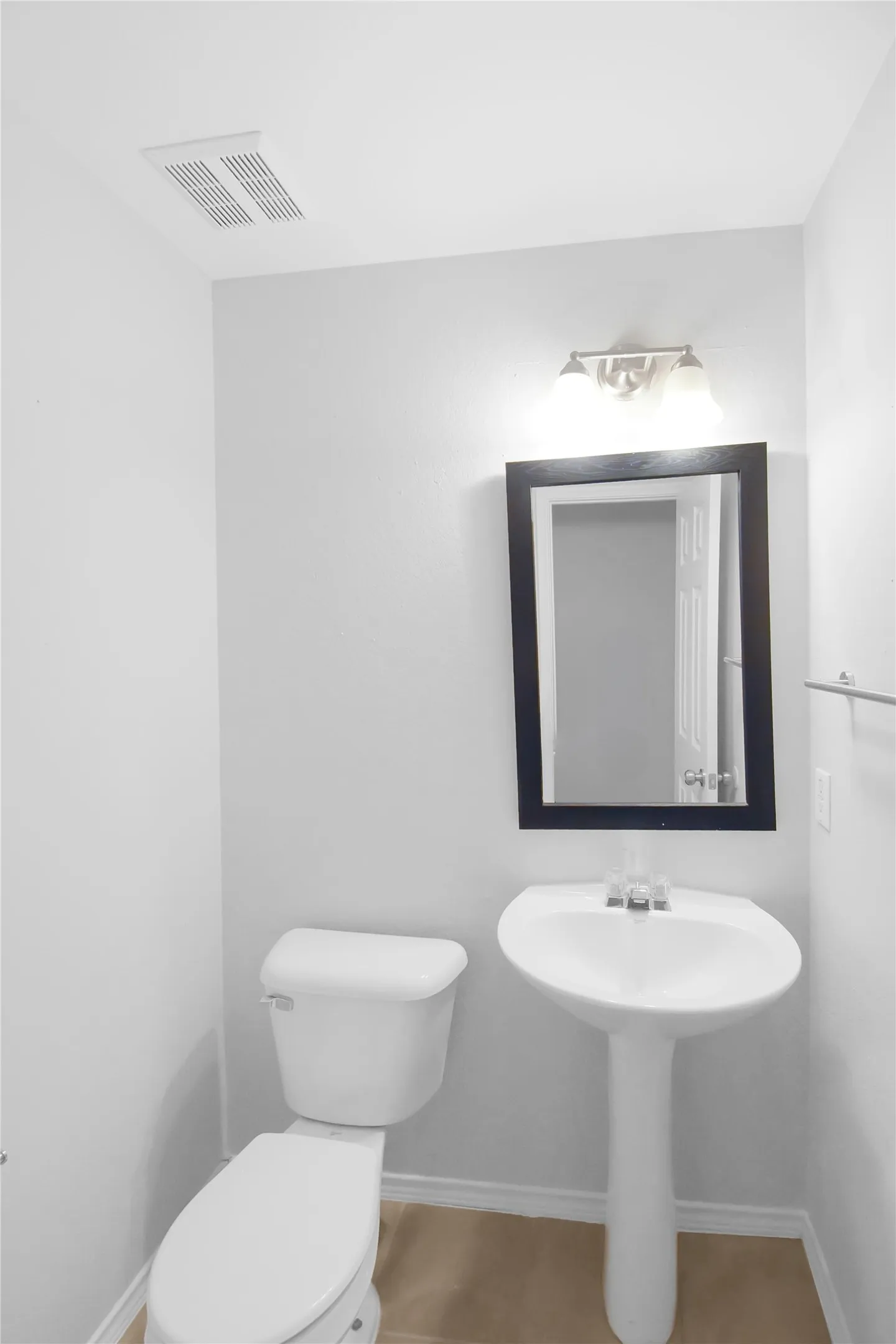 Powder room featuring a pedestal sink with chrome faucet, white ceramic toilet, and recessed ceiling ventilation