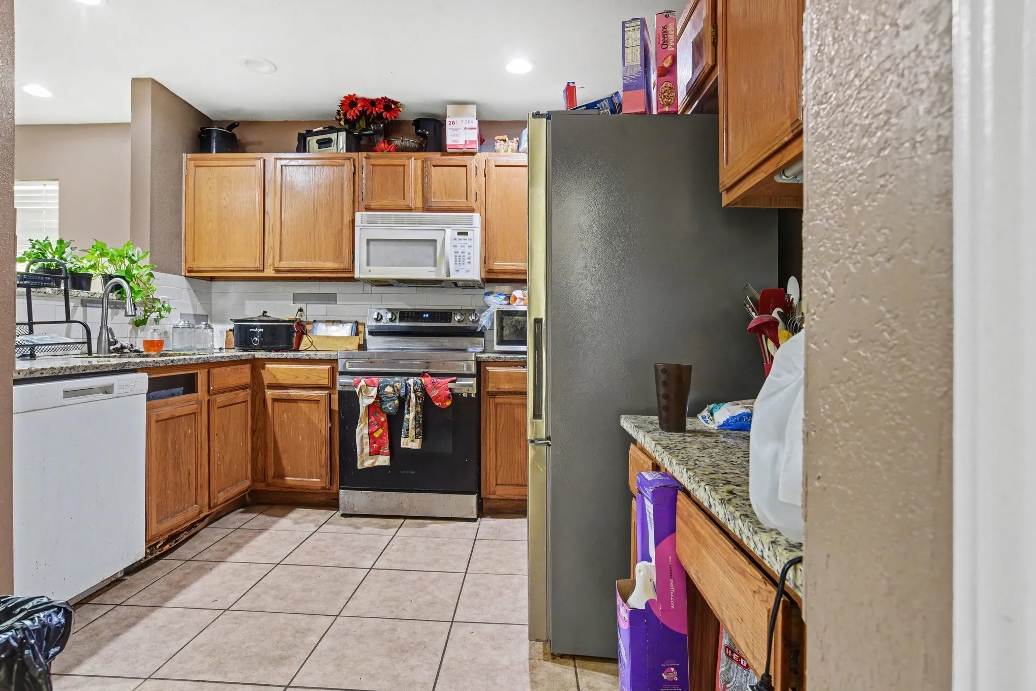 Kitchen overview highlighting stainless steel range oven, built-in microwave, and ample counter workspace.