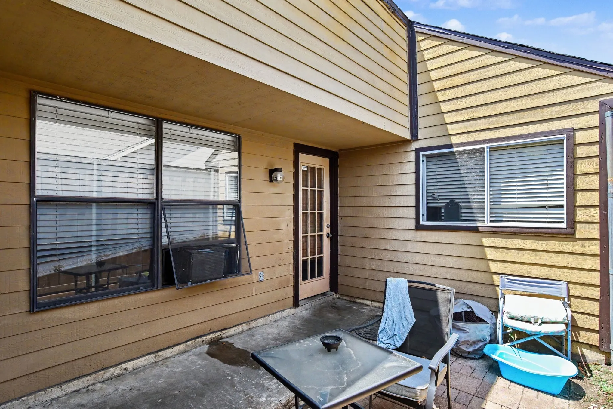 Covered rear patio nook featuring direct exterior door access to the residence.