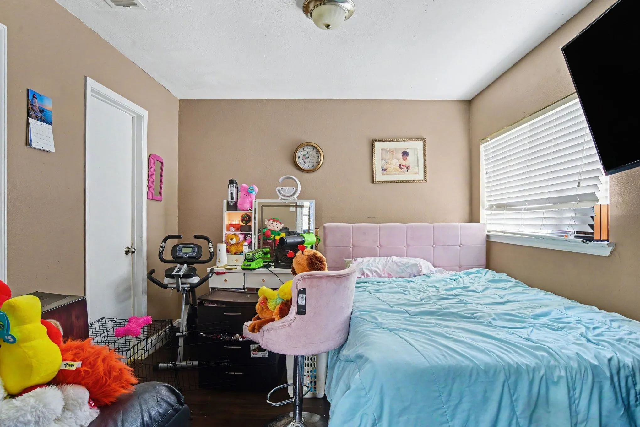 Secondary bedroom equipped with bright window lighting, ceiling fan, and clean wall finishes.