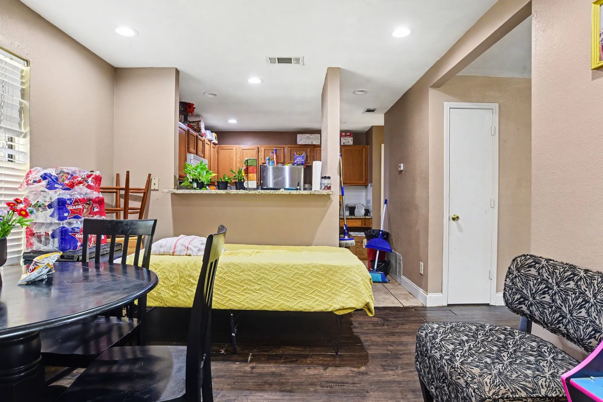 Dining room view displaying light-filled window, dark wood-style flooring, and neutral wall tones.