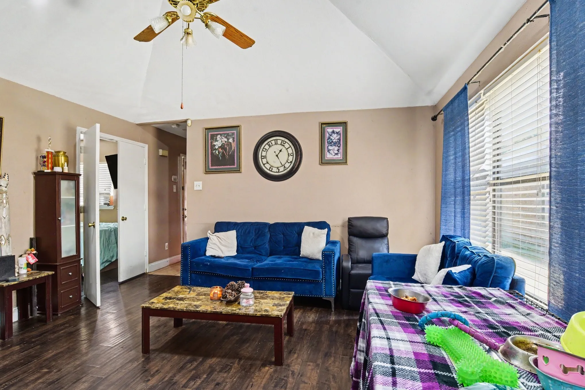 Broad open-concept living space framed by high vaulted ceilings, overhead ceiling fan, and generous floor space.