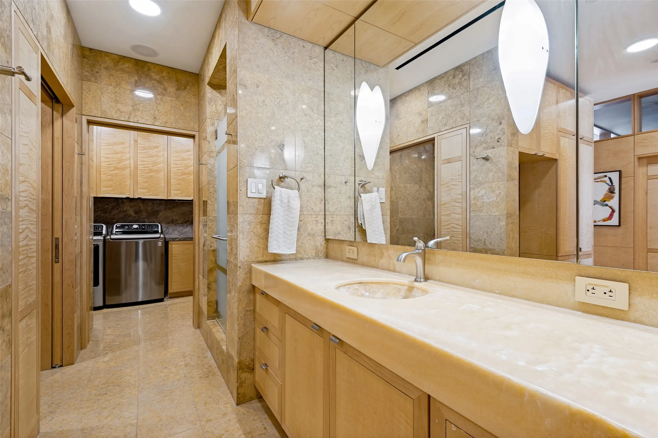 Integrated vanity with a single basin, extensive countertop, and mirrored wall