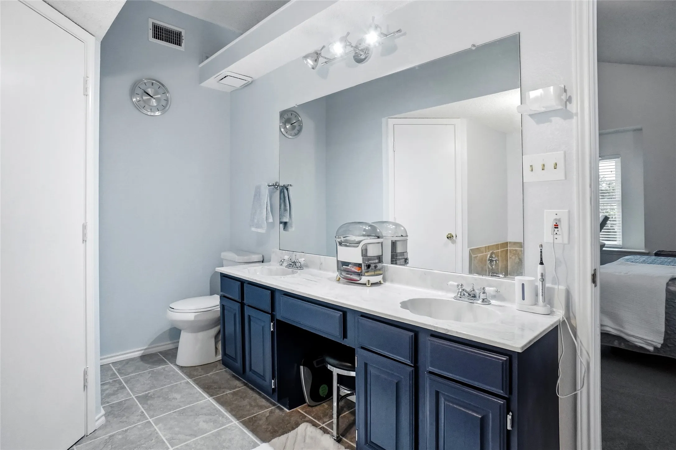 Dual vanity with white countertop, undermount sinks, and dark wood-finish cabinetry
