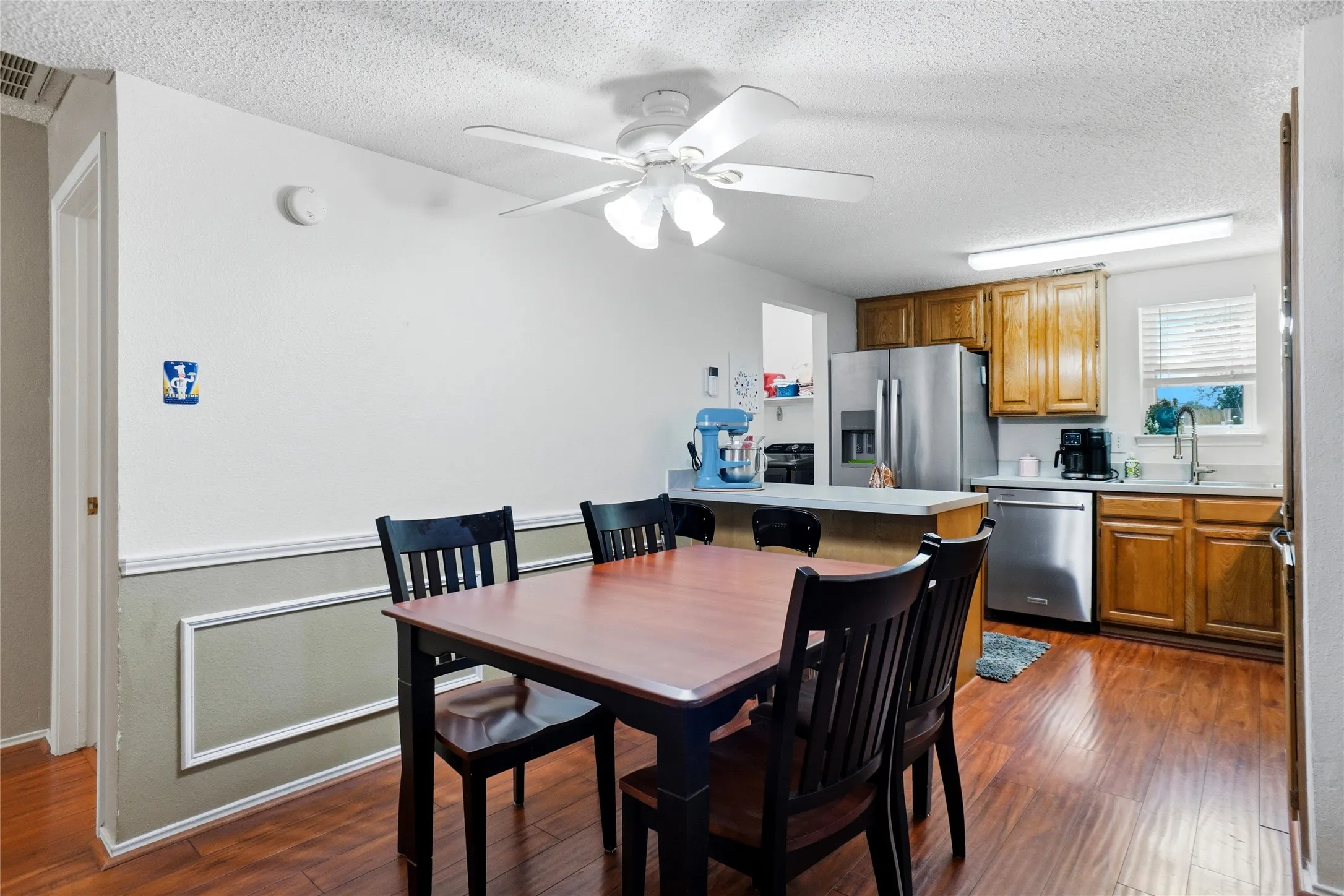 Kitchen with wood-finish flooring, wood cabinetry, and stainless steel appliances