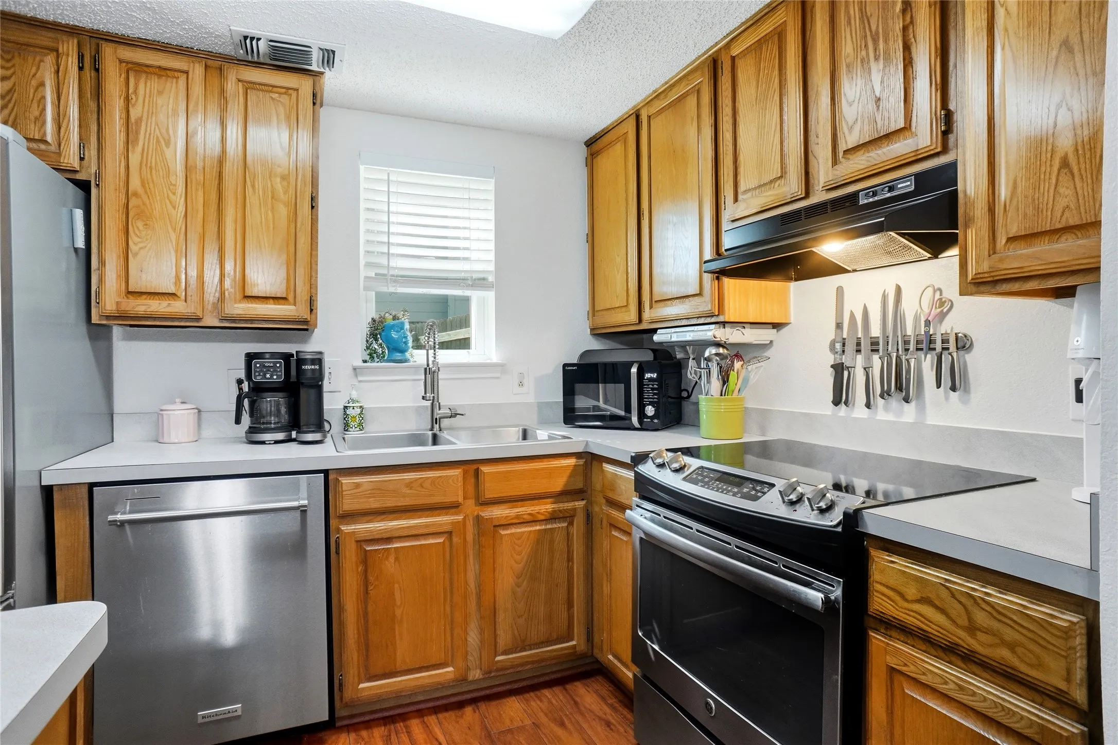 Kitchen with wood-finish cabinetry and light-toned countertops