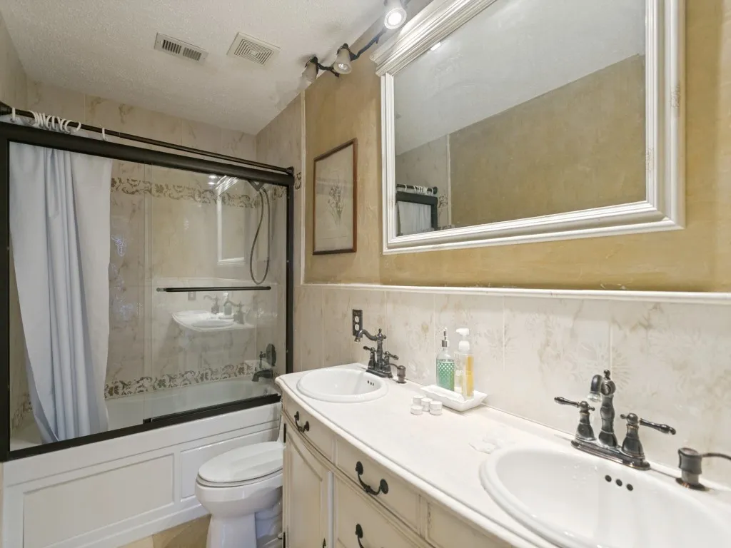 Dual vanity with integrated sinks, white countertop, and oil-rubbed bronze fixtures