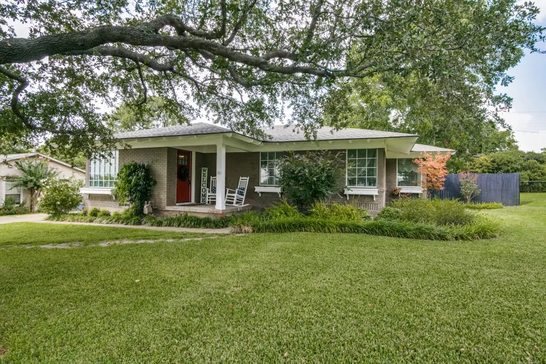 Brick exterior with a covered front porch and a prominent red entry door