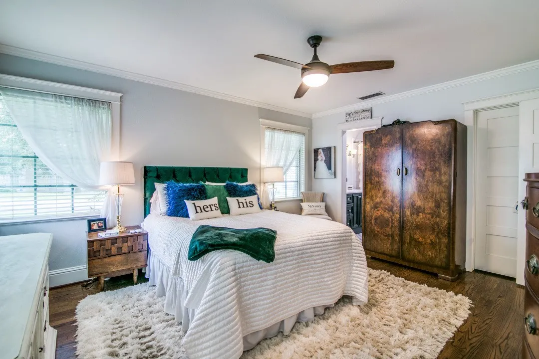 Wood-finish flooring, ceiling fan with integrated lighting, crown molding, and white interior doors