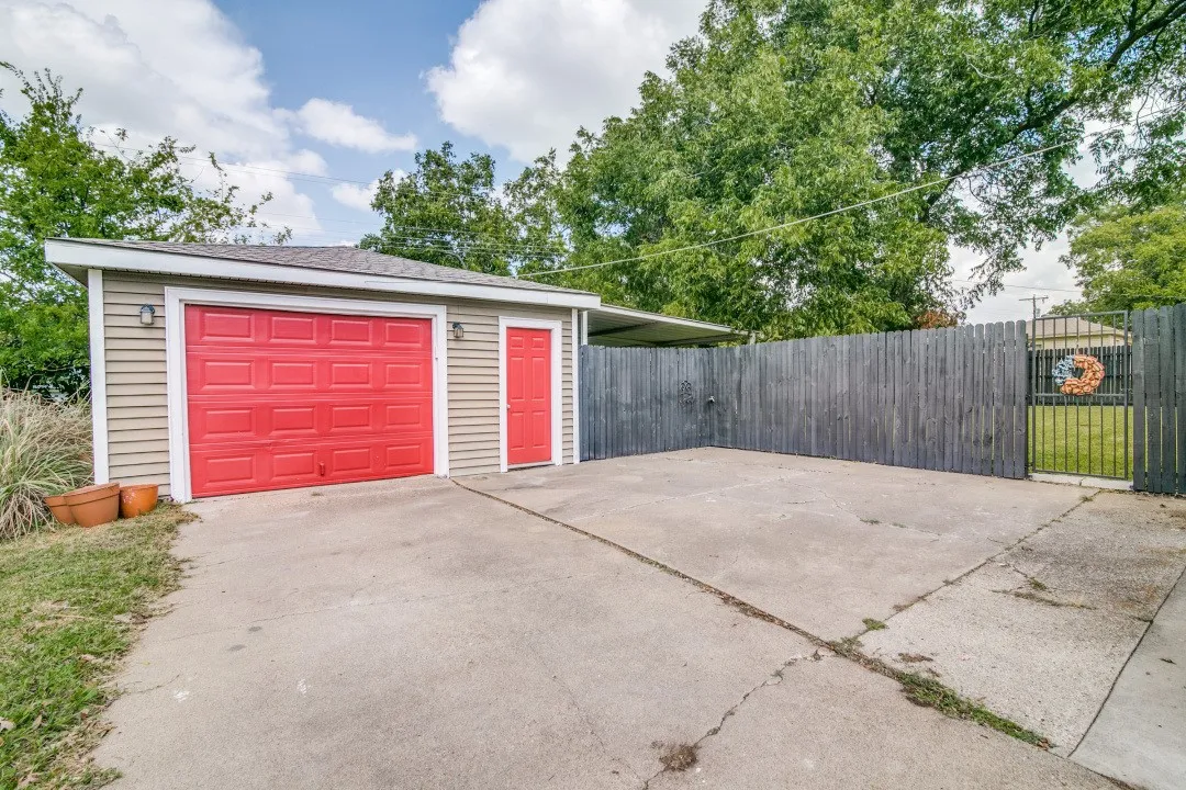 Detached garage with red overhead door and personal entry door