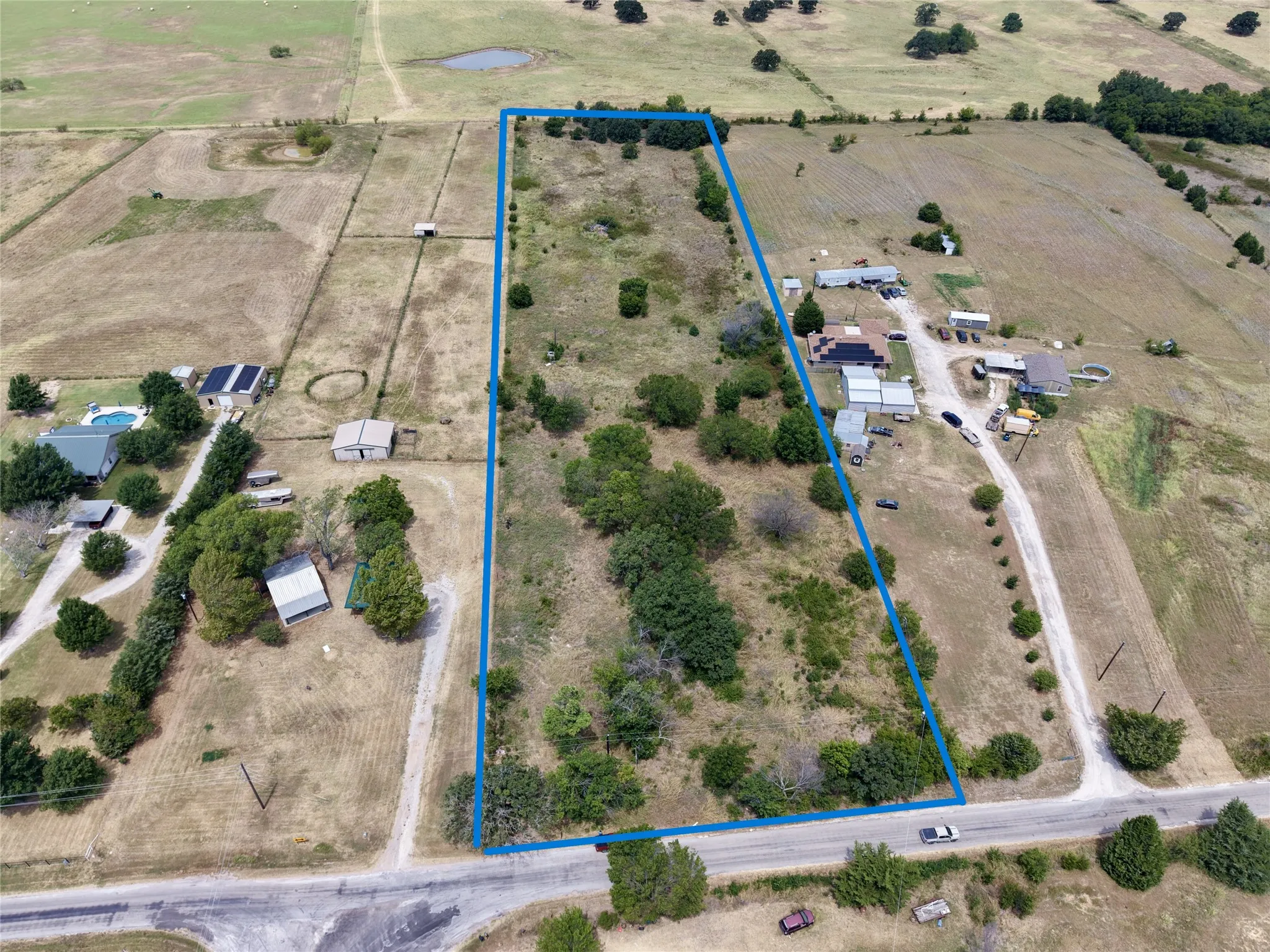 Expansive undeveloped land featuring a combination of open fields and mature trees
