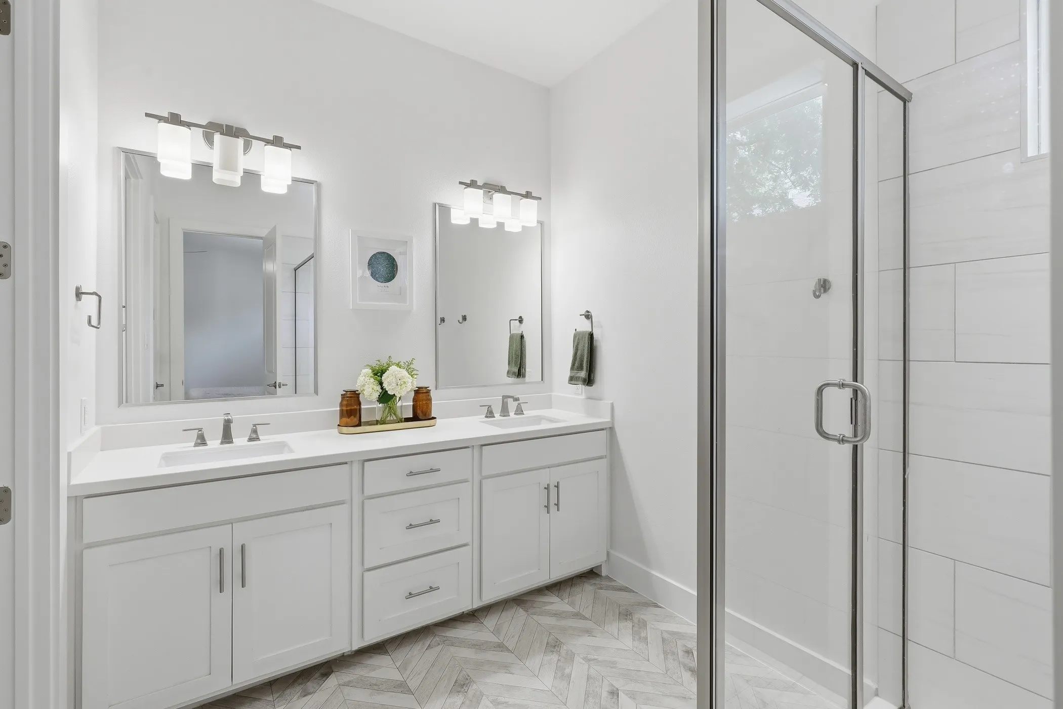 Dual vanity with white cabinetry, integrated sinks, and polished chrome fixtures