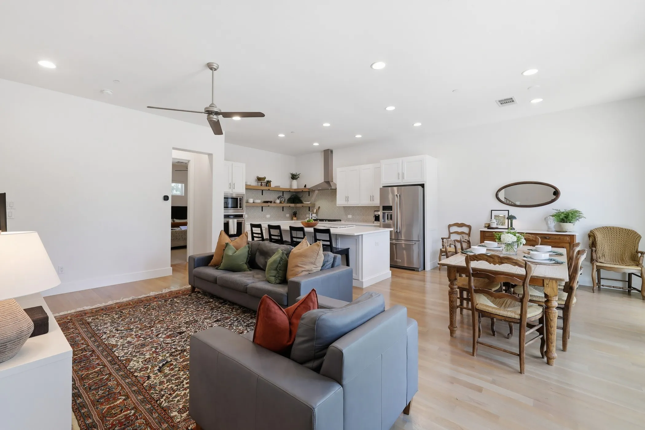Open-concept living space featuring wood-finish flooring, recessed lighting, and a ceiling fan