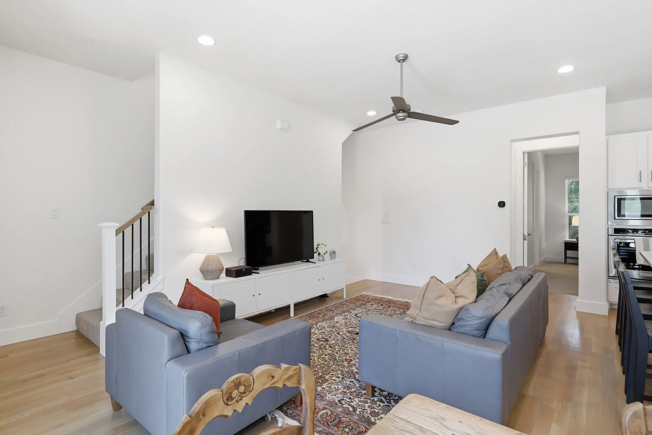 Open-concept living space featuring wood-finish flooring, recessed lighting, and a ceiling fan