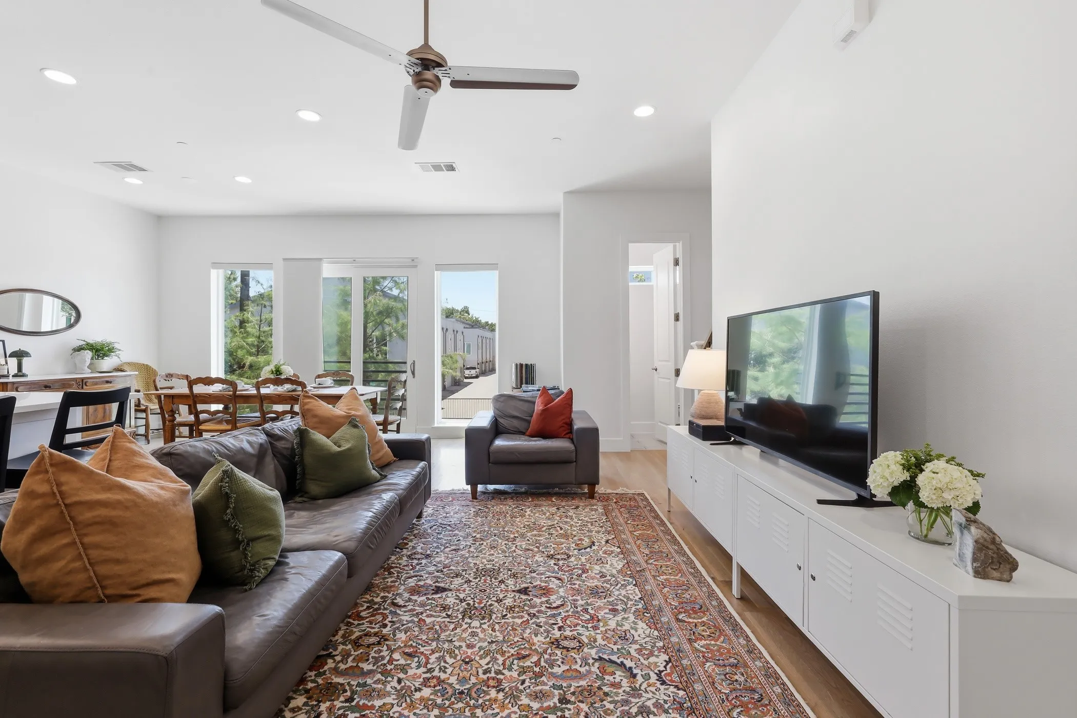 High ceilings with recessed lighting, wood-finish flooring, and a ceiling fan