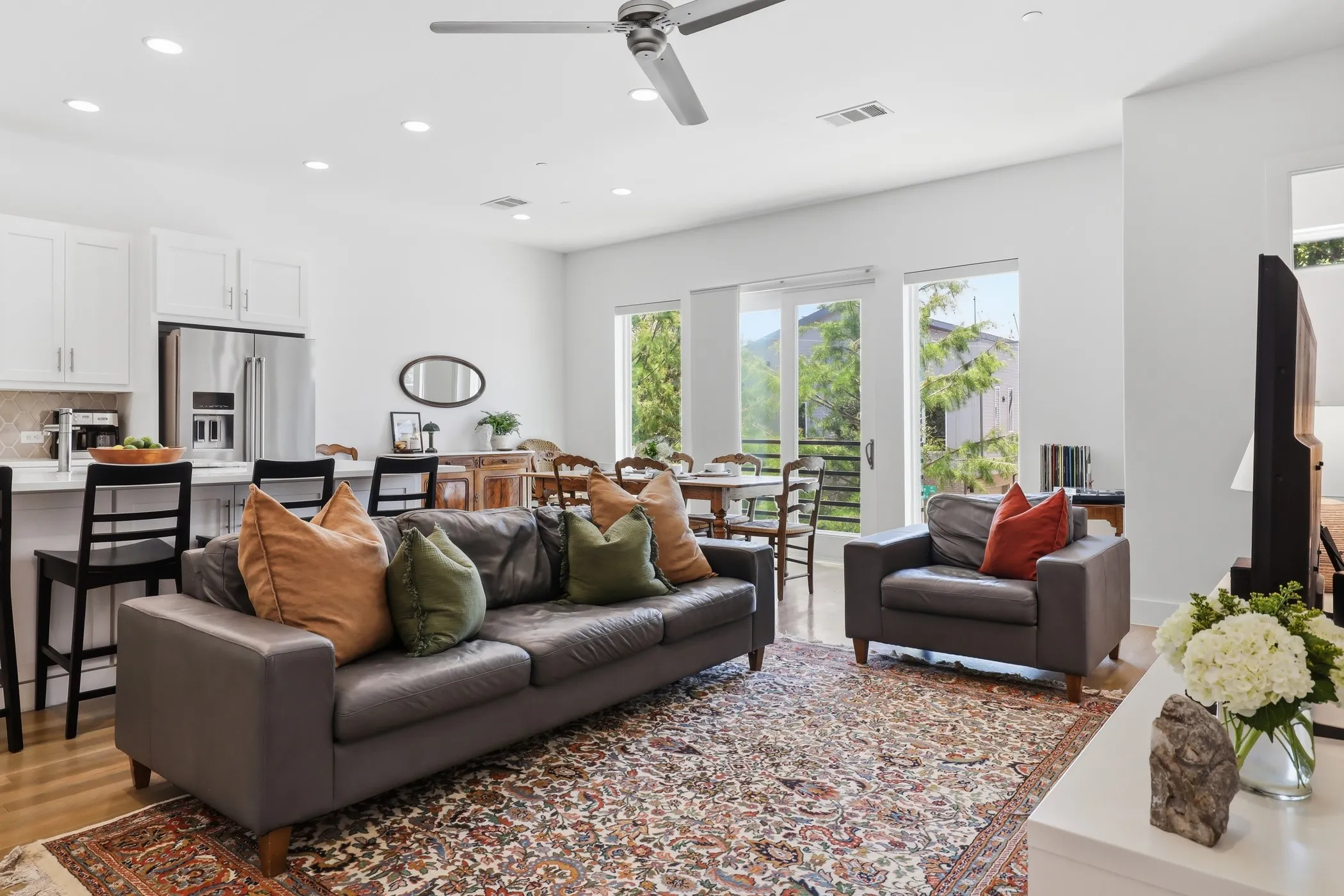Open-concept living space with wood-finish flooring, recessed lighting, and a ceiling fan