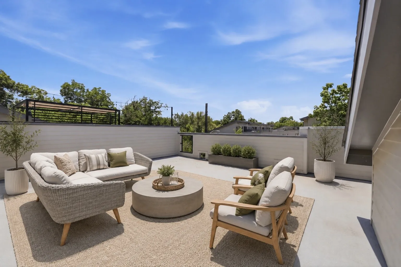 VIRTUAL STAGIN - Inso for how the rooftop could look. Expansive rooftop deck featuring a concrete surface, built-in planter boxes with greenery, and a surrounding privacy wall