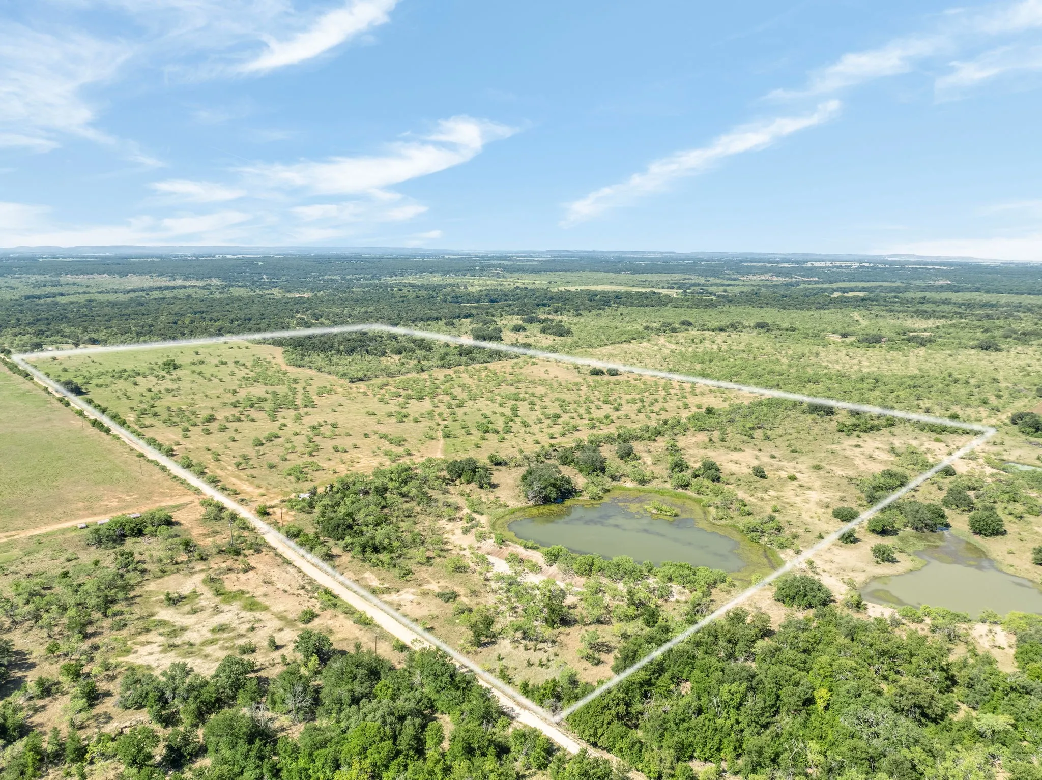 Expansive land parcel featuring multiple ponds and diverse tree coverage