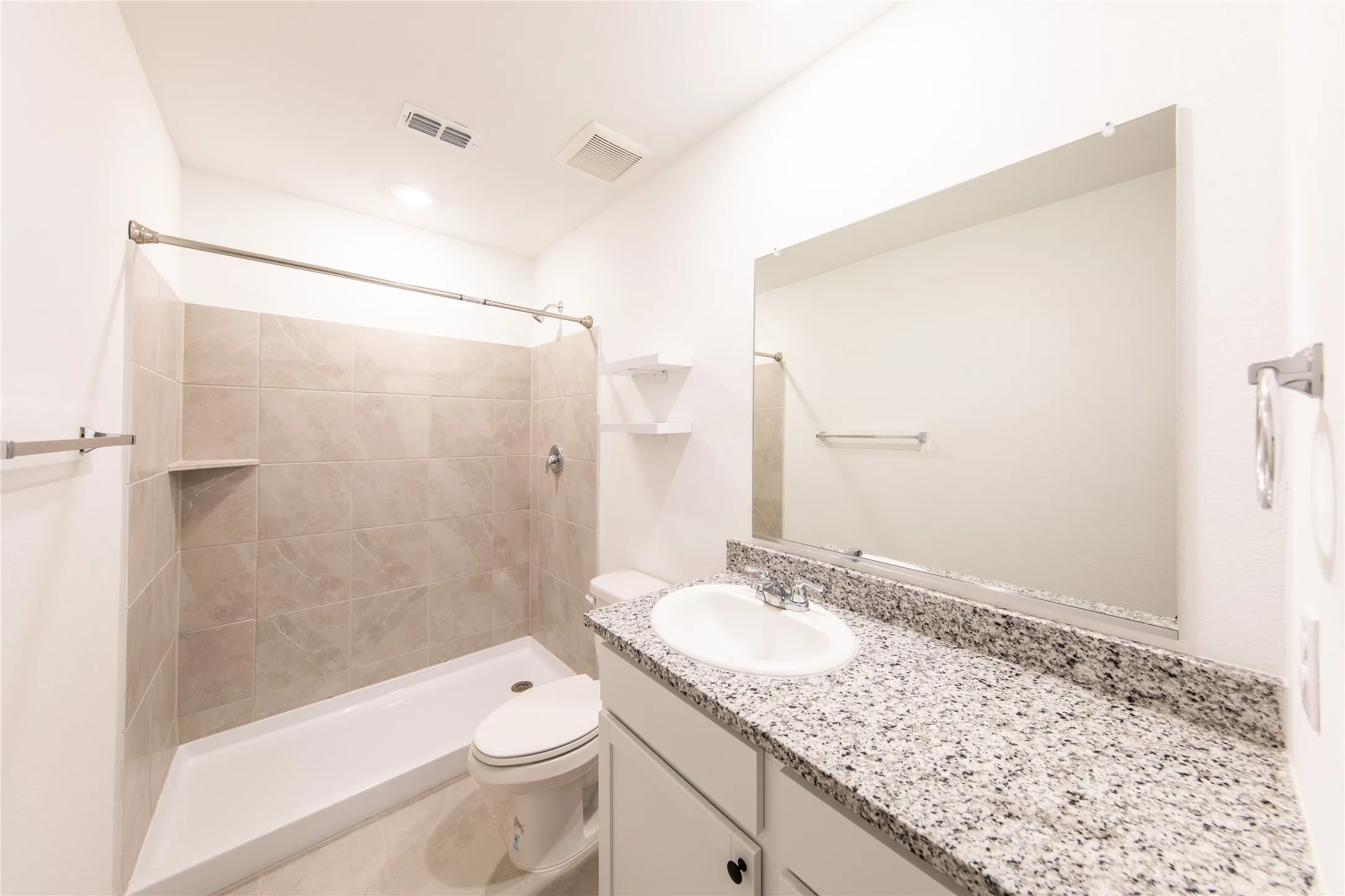 Bathroom with oversized vanity, toilet, and tile flooring