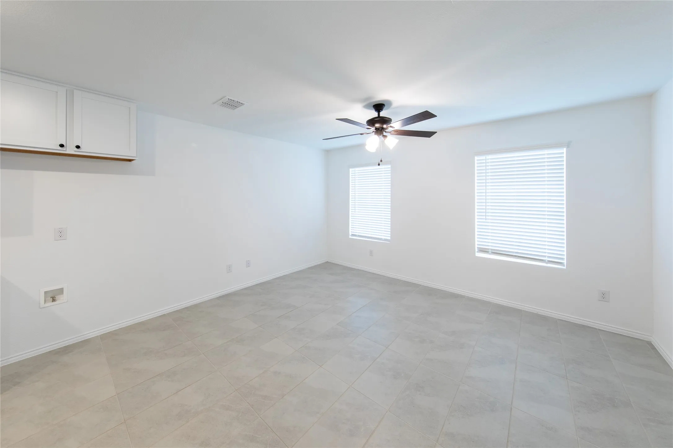 Tiled empty room with ceiling fan