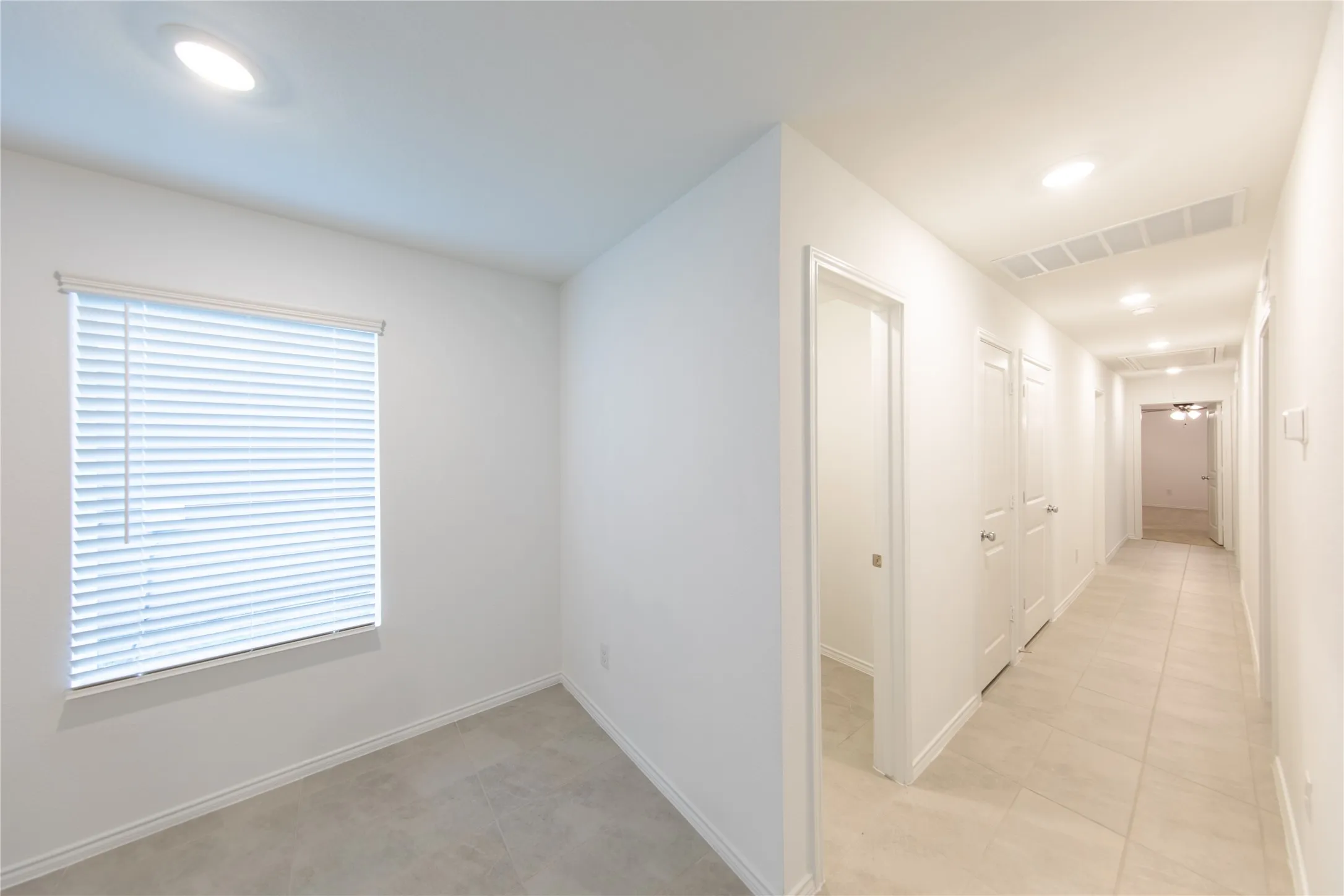 Hall with a wealth of natural light and light tile floors