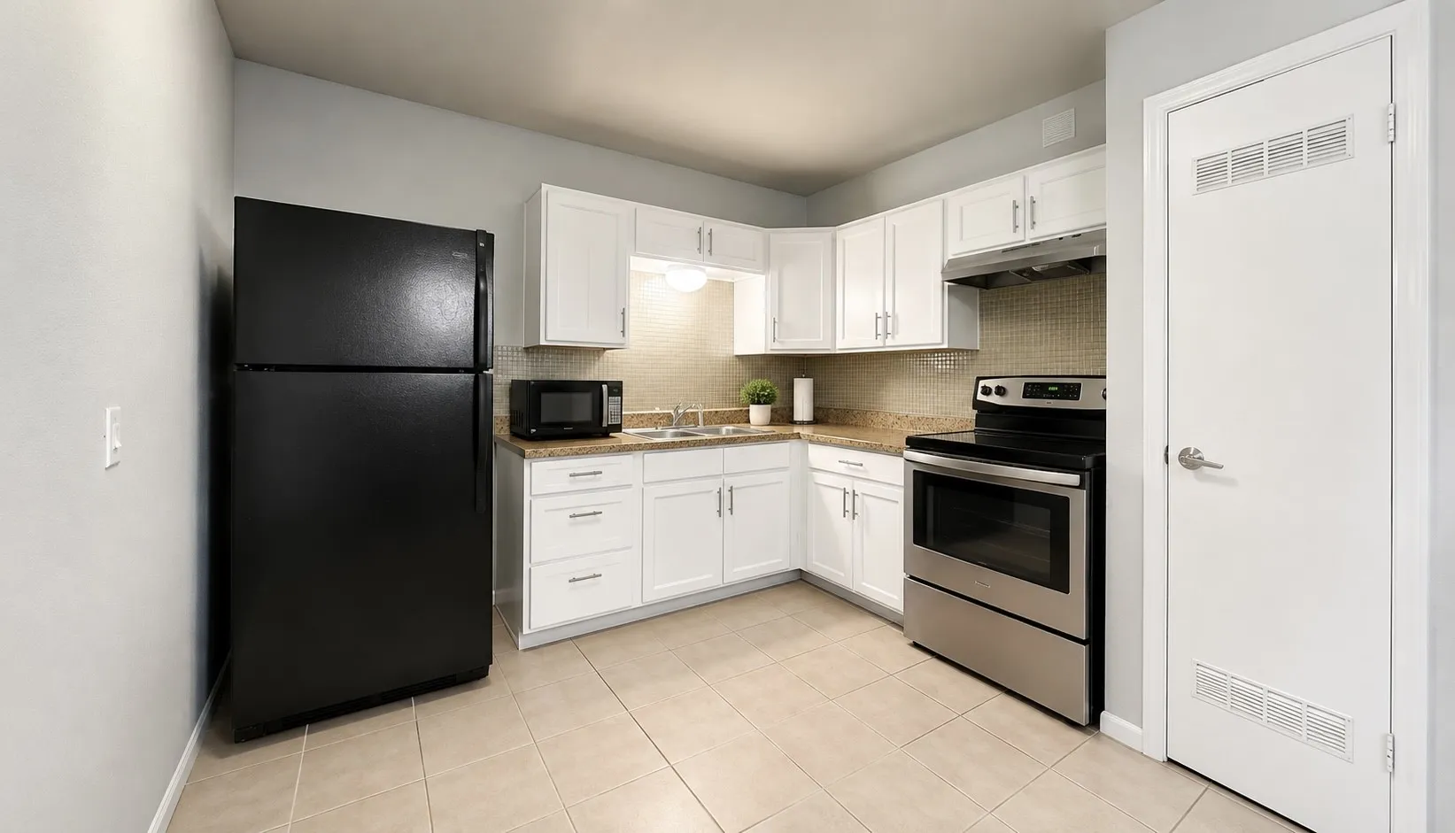 Kitchen featuring white cabinetry, light-toned tile flooring, and stainless steel appliances