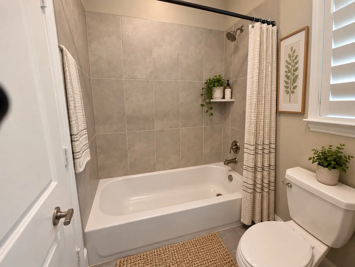 Bathtub with tile surround, built-in shower shelf, and a shower/tub combination