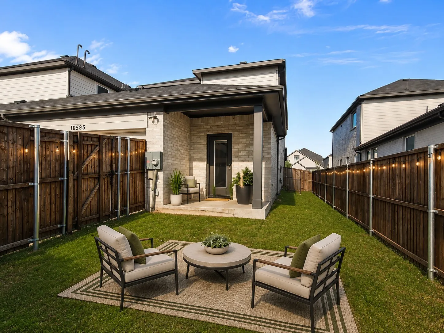 Virtually Staged backyard featuring a manicured lawn, dark wood fencing, and a covered back patio