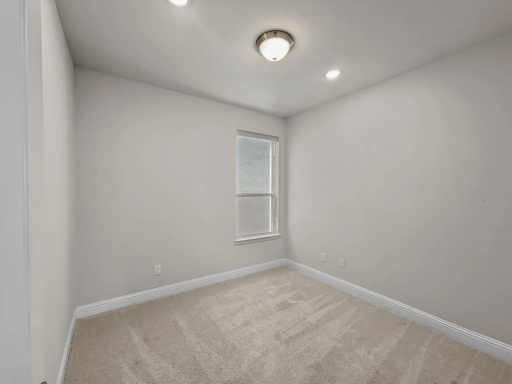 Recessed lighting, wall-mounted light fixture, neutral wall color, window with blinds, and carpeted flooring