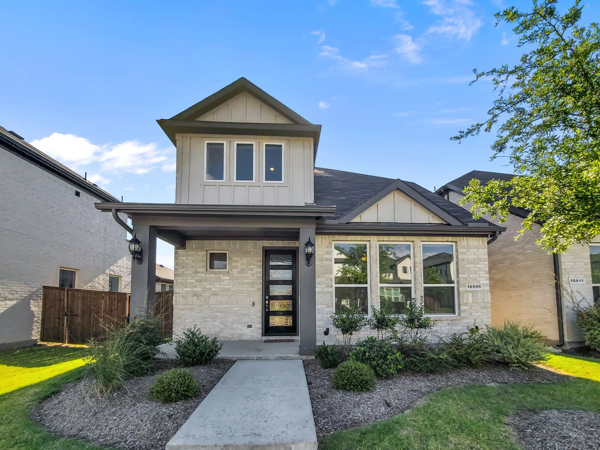Contemporary exterior showcasing a light brick facade, dark trim elements, and a covered entry