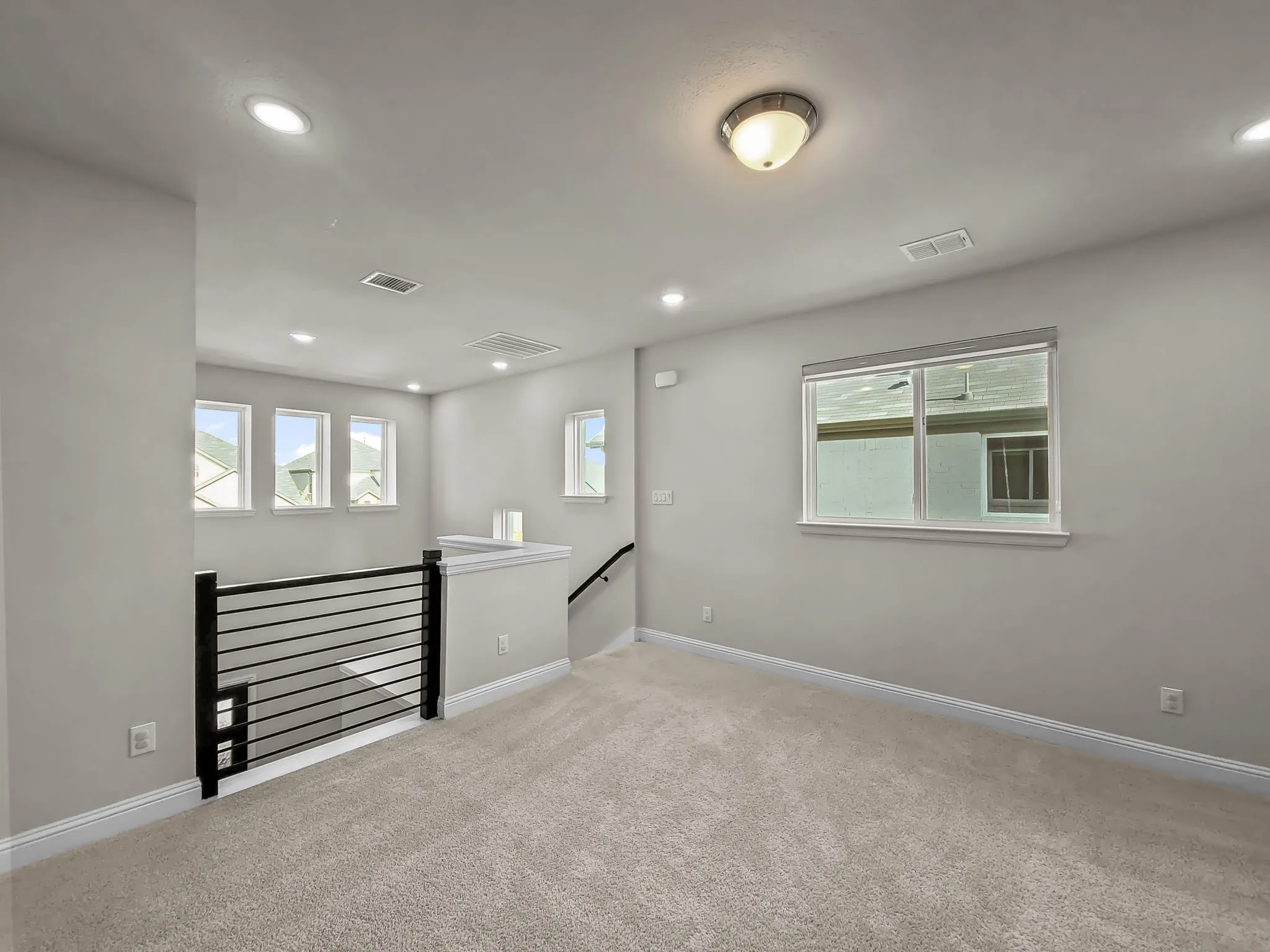 Recessed lighting, light gray wall paint, and plush carpeting