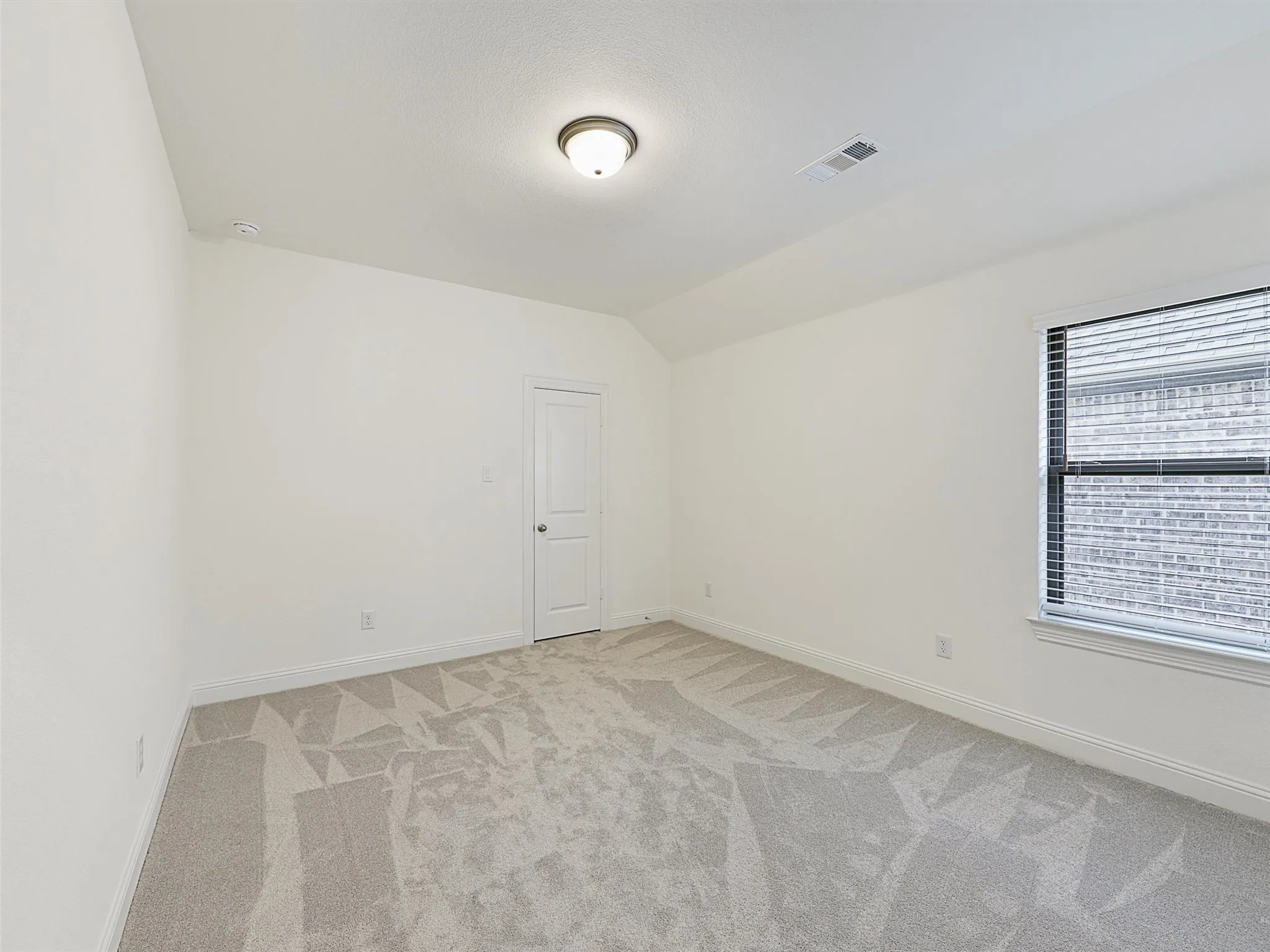 Neutral-toned carpeting, white painted walls, and a recessed window with blinds