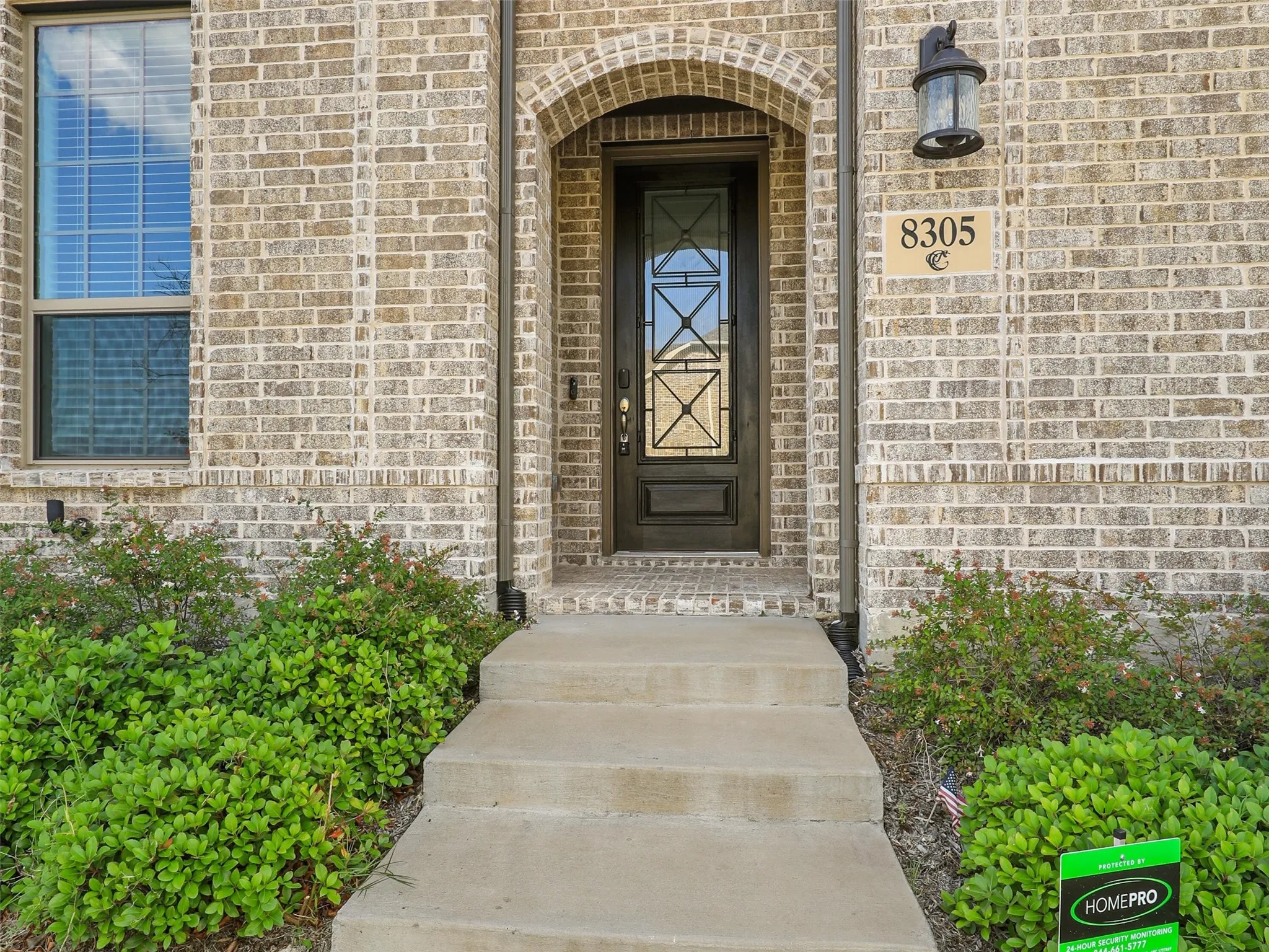Welcoming entry featuring a brick exterior with arched doorway, sidelite detailing, and brass hardware