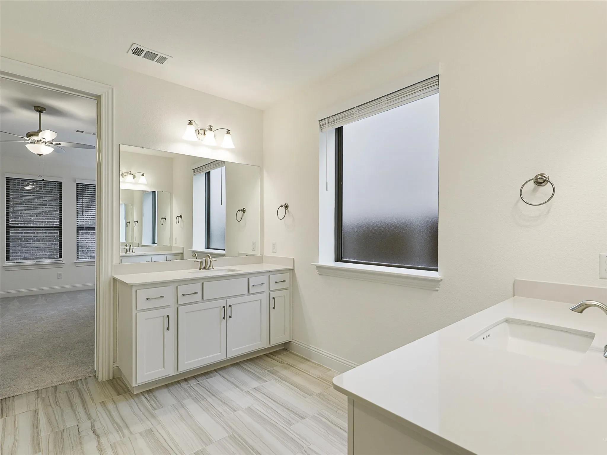 Dual vanity with white cabinetry and integrated sinks
