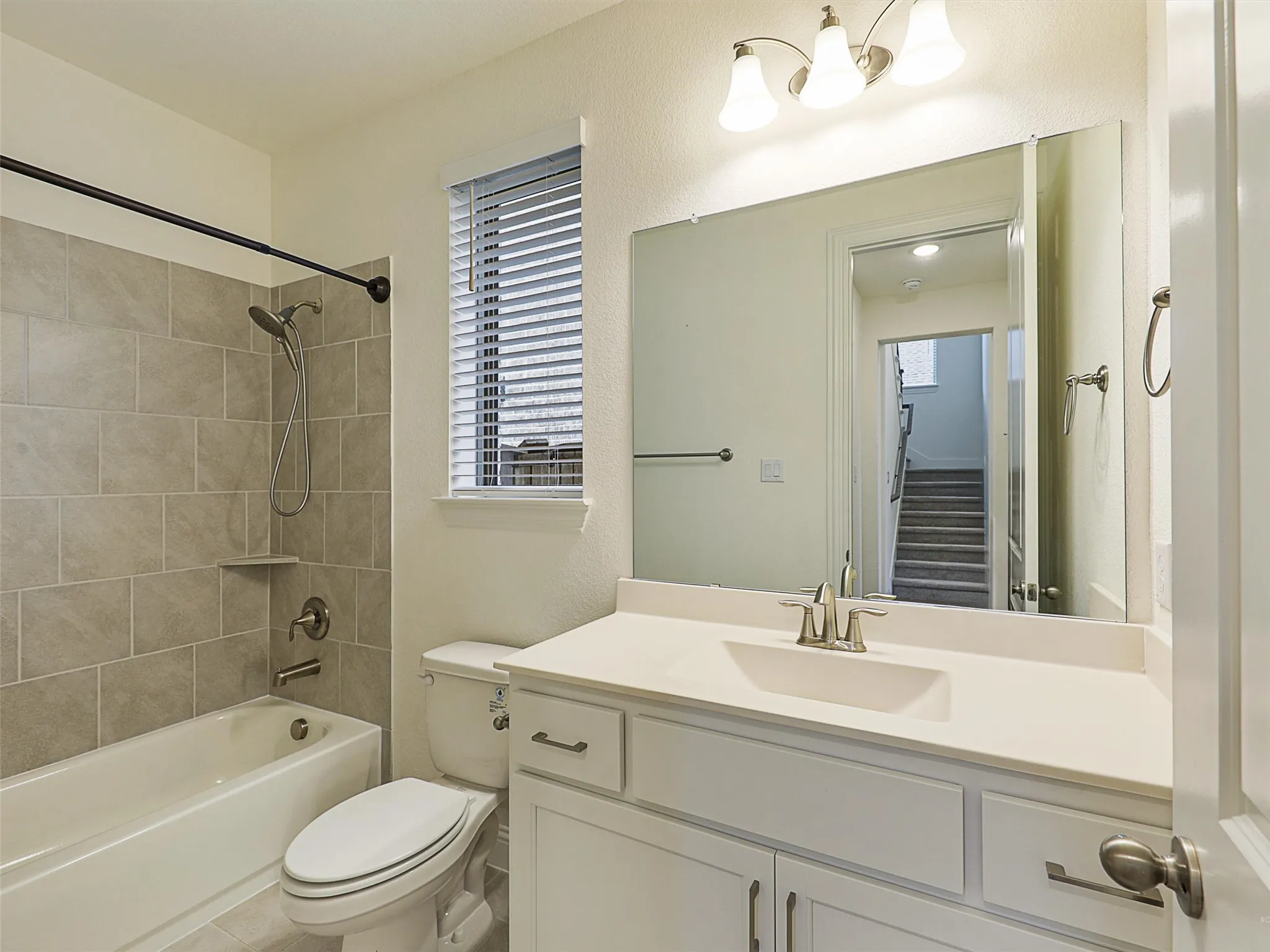 Tub/shower combination with subway tile surround, integrated shelf, and brushed nickel fixtures