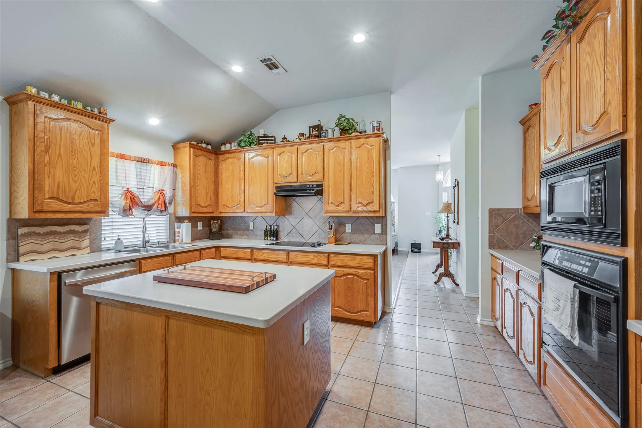 Kitchen featuring wood cabinetry, white countertops, tile flooring, built-in oven, and a built-in microwave