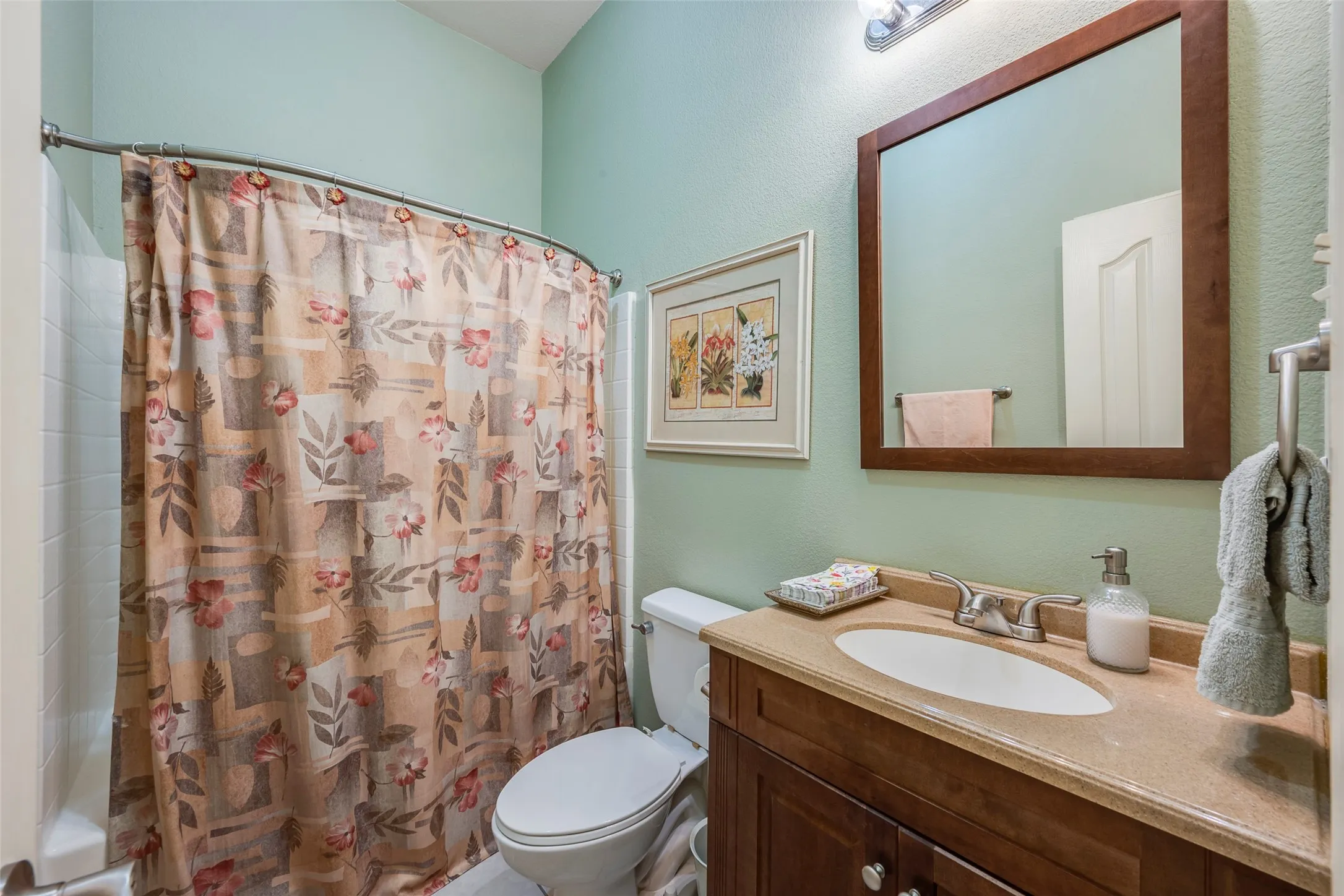 Wood-finish vanity with a single basin sink and polished chrome faucet