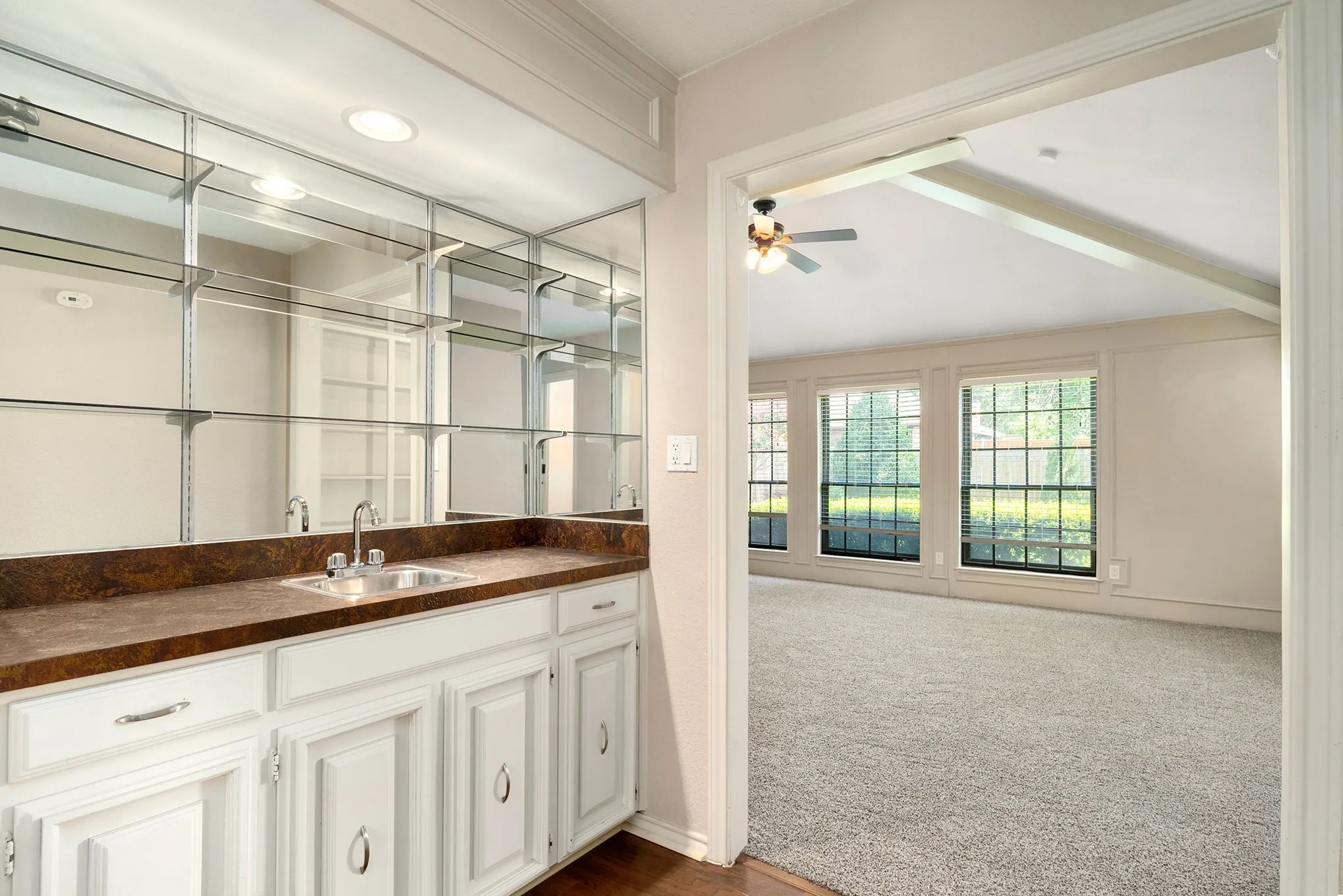 Bar area featuring dark carpet, a ceiling fan, and dark wood finished floors